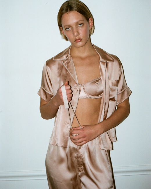 The Gita Underwire Bra in nude worn under the Shelby silk pajama top also in nude, worn on a model.