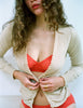 front shot lifestyle image of woman wearing beige cardigan, red lace bra and panty