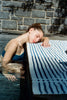 on model, editorial photo of blue bandeau top in pool