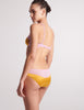 back view of woman in yellow and pink silk bra and panty