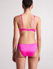 On model image of back of pink silk bra and pink silk panty