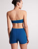 On model image of back view of blue bandeau and blue swim shorts