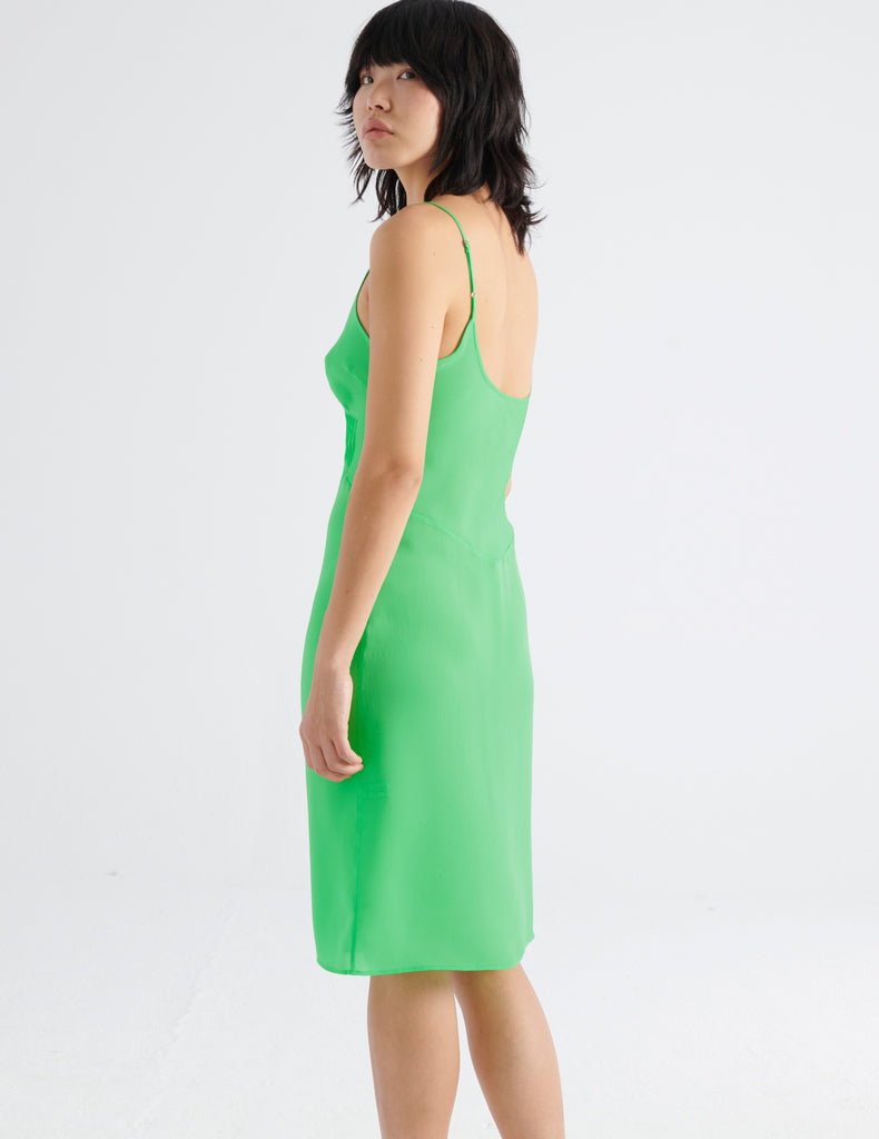 Back view of the silk cadel slip in bright green worn on a model.